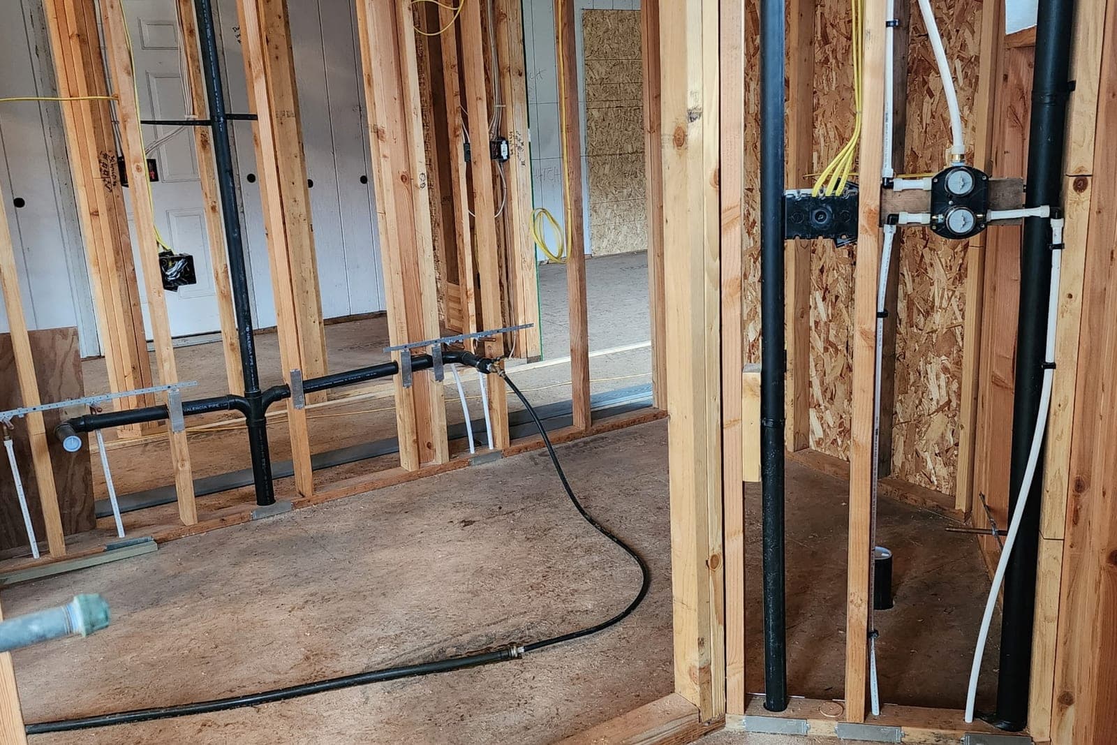 Plumbing rough-in inside framed walls during a remodel