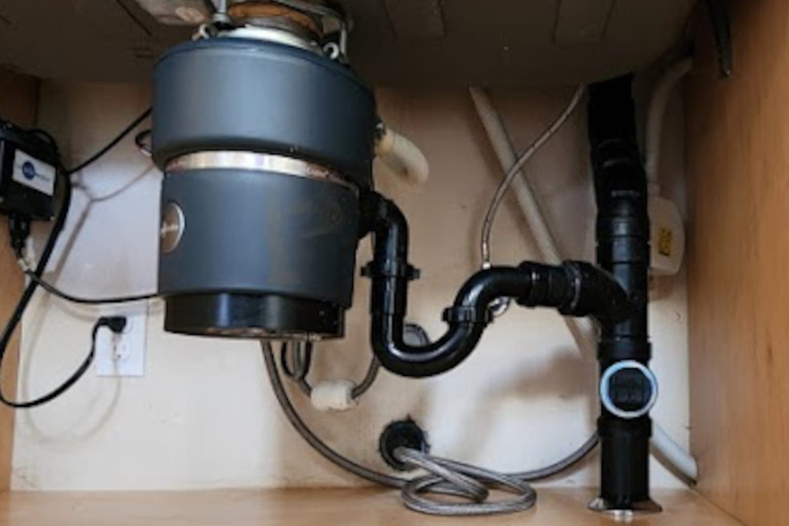 Garbage disposal and drain plumbing installed under a kitchen sink