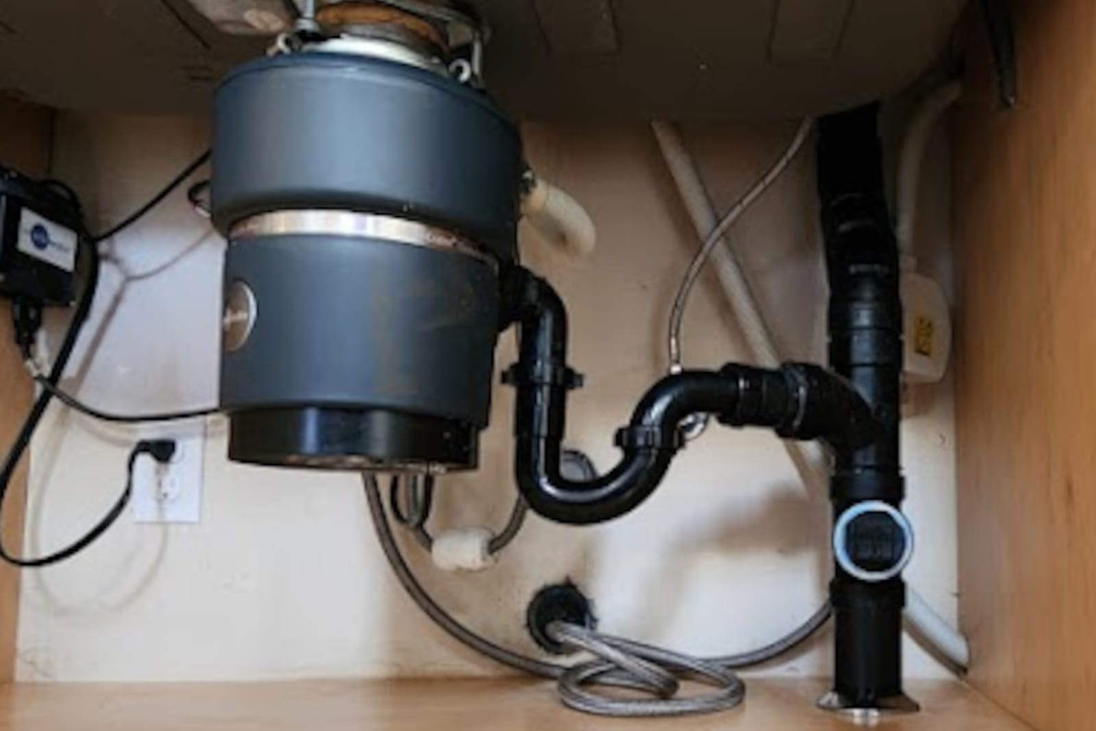 Garbage disposal and drain plumbing installed under a kitchen sink